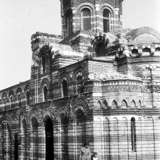 Black and white photo of a building with two people.