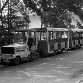 Vintage miniature train with a child standing nearby.