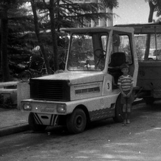 Vintage miniature train with a child standing nearby.