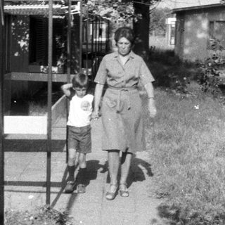 Woman and child walk along a paved path.