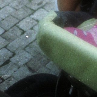 Baby in stroller with a smiling woman nearby.