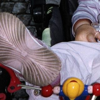 Baby sleeps peacefully in a stroller with a toy.