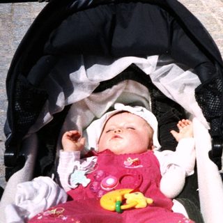 Baby in stroller near artist painting outdoors.