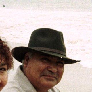 Couple sitting on rocks, enjoying a beach day.