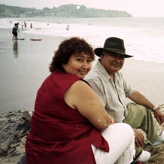 Couple sitting on rocks, enjoying a beach day.