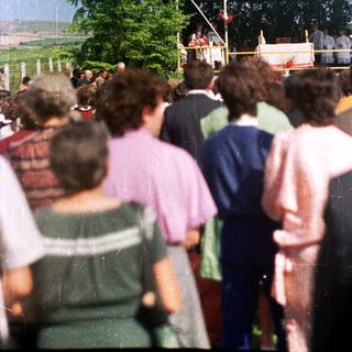 People gather outdoors, seemingly attending an event or ceremony.