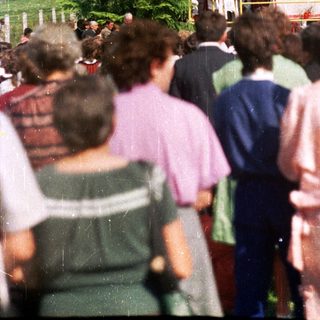 People gather outdoors, seemingly attending an event or ceremony.
