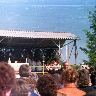 Outdoor religious ceremony with a crowd of onlookers.