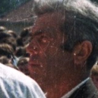 People gather outdoors, possibly at a religious ceremony.