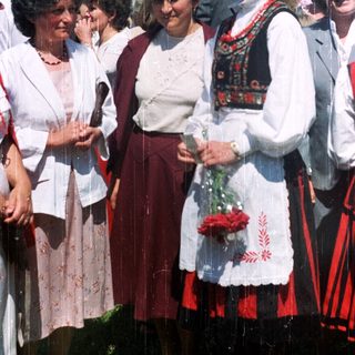 Group of women in traditional dress outdoors.
