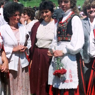 Group of women in traditional dress outdoors.