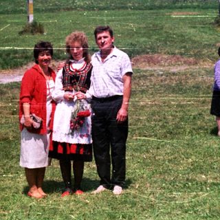 People pose for a photo in a grassy, open field.