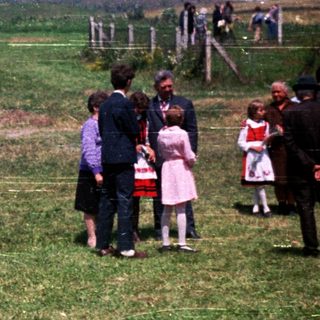 People pose for a photo in a grassy, open field.