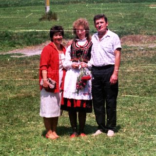 People pose for a photo in a grassy, open field.