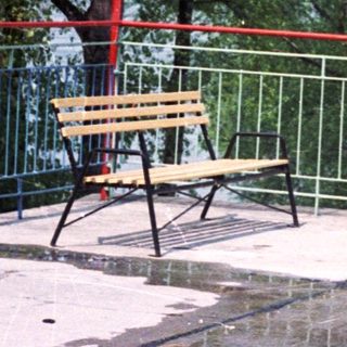 Four people stand on a patio overlooking a river.