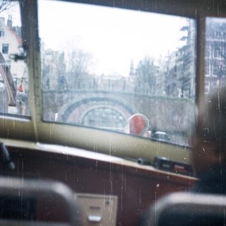 View from a bus, showing a bridge and buildings.