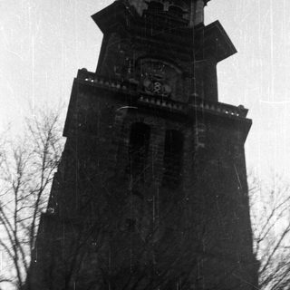 Tall, ornate stone tower with a pointed roof.