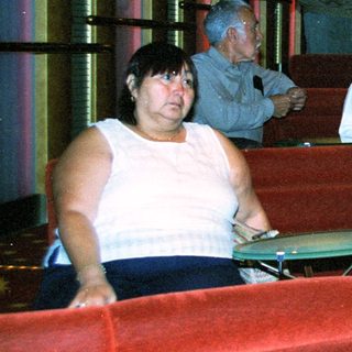 Group of people seated in tiered, red stadium-style seating.