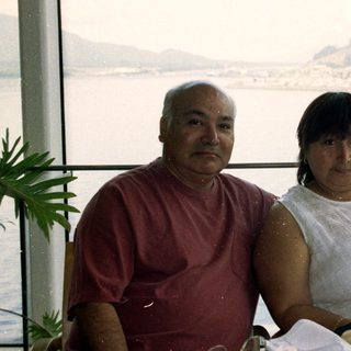 Couple seated at a table with a scenic waterfront view.