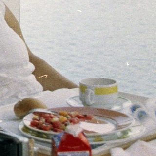Couple seated at a table with a scenic waterfront view.