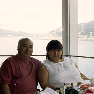 Couple seated at a table with a scenic waterfront view.
