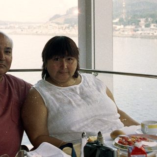 Couple seated at a table with a scenic waterfront view.