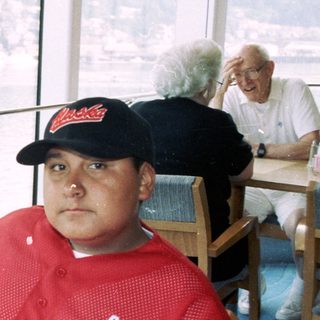 Men seated at a table with a waterfront view.
