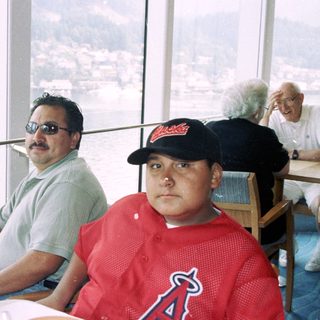 Men seated at a table with a waterfront view.