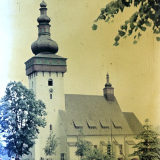 People relax near a church with a distinctive onion dome.