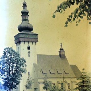 People relax near a church with a distinctive onion dome.