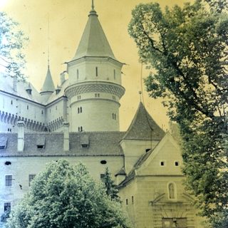 Historic castle exterior with towers and surrounding greenery.