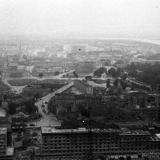 Overhead view of a city, possibly post-war, with dense buildings.