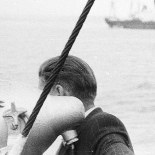 Black and white photo of people on a ship at sea.