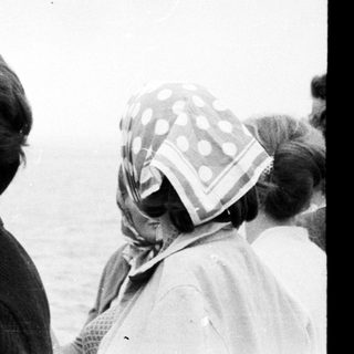 Black and white photo of people on a ship at sea.