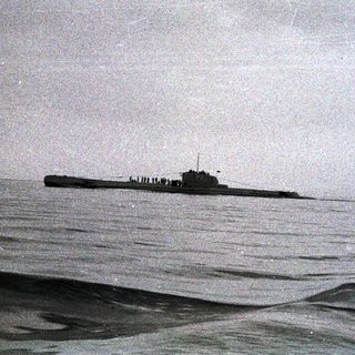 A submarine surfaces in a body of water.