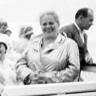 Group of people on a bench, likely at the seaside.