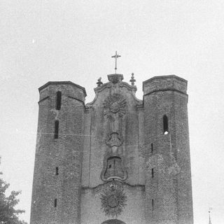 Black and white photo of a church facade with trees.