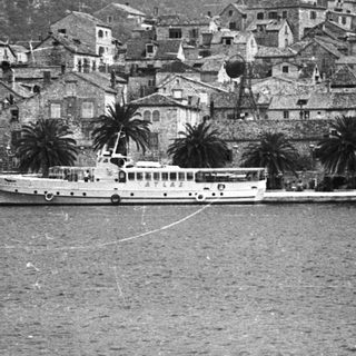 Coastal town with boats and hillside dwellings.