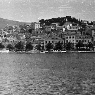 Coastal town with boats and hillside dwellings.