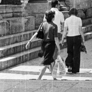 Black and white image of ancient ruins with people.