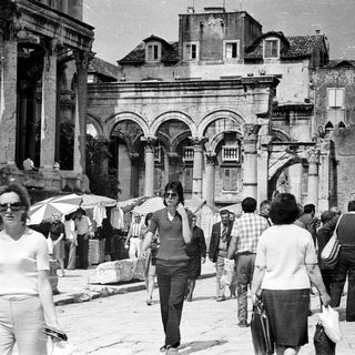 Black and white image of people near ancient ruins.