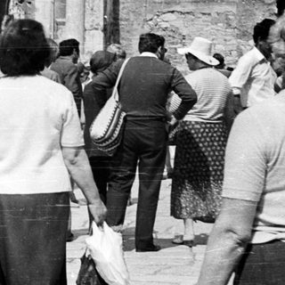 Black and white image of people near ancient ruins.