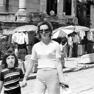 Black and white image of people near ancient ruins.