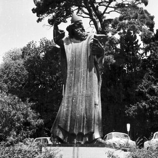 Black and white photo of a statue and surrounding greenery.
