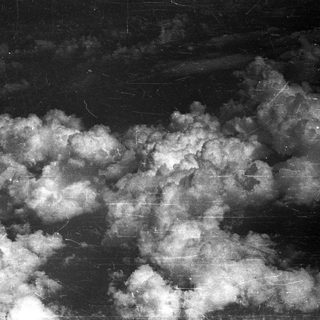 Black and white image showing clouds against a dark background.
