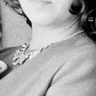 Woman holding baby, wearing a decorative hat.