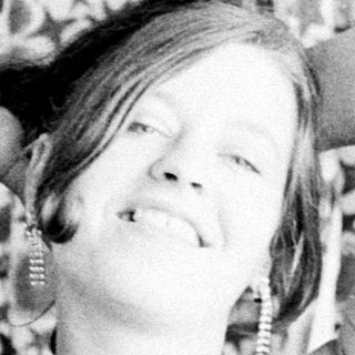 Woman with arms behind her head, child nearby.