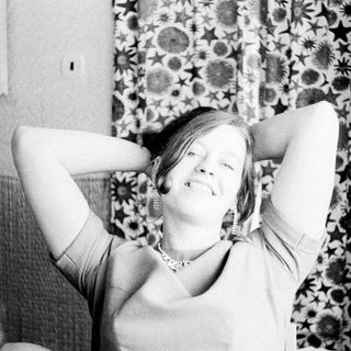 Woman with arms behind her head, child nearby.