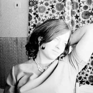 Woman holds her hand up to her armpit.