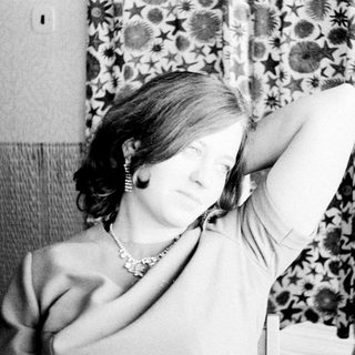 Woman holds her hand up to her armpit.